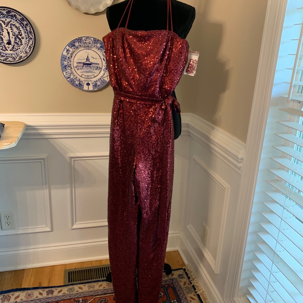 Burgundy sequined jumpsuit with waist tie and spaghetti straps.